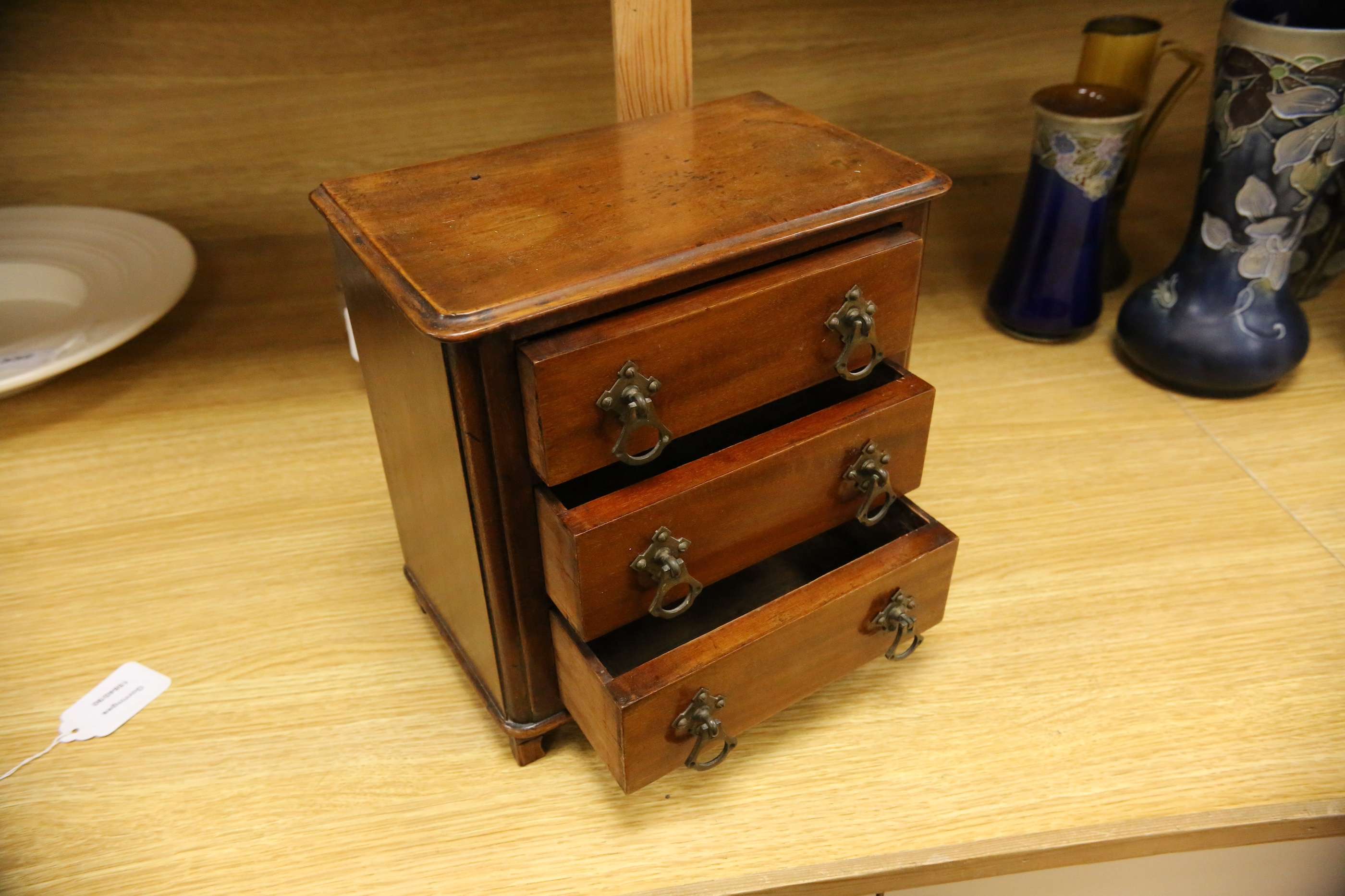 An Edwardian miniature mahogany three drawer chest, 26cm wide x 28cm high. Condition - fair to good